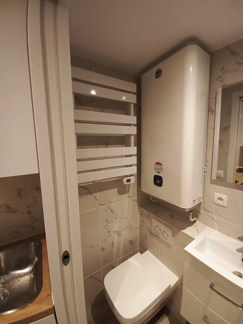 Salle d’eau : WC suspendu, chauffe-eau, radiateur sèche-serviettes.