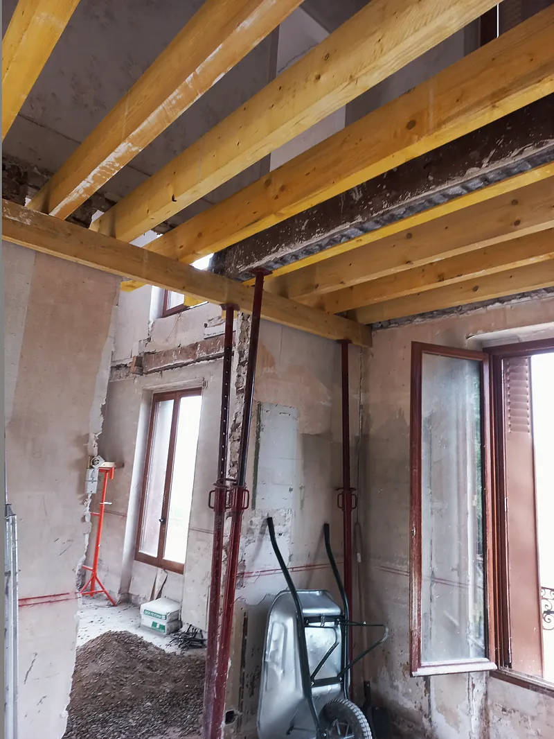 Solives neuves en bois sur une poutre métallique, étais en place.