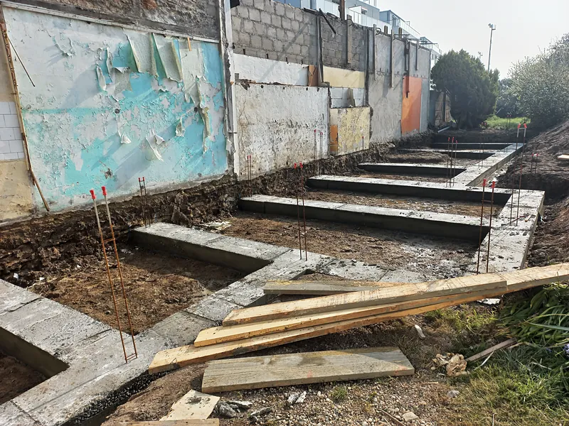 Les semelles de fondation coulées le long du mur.