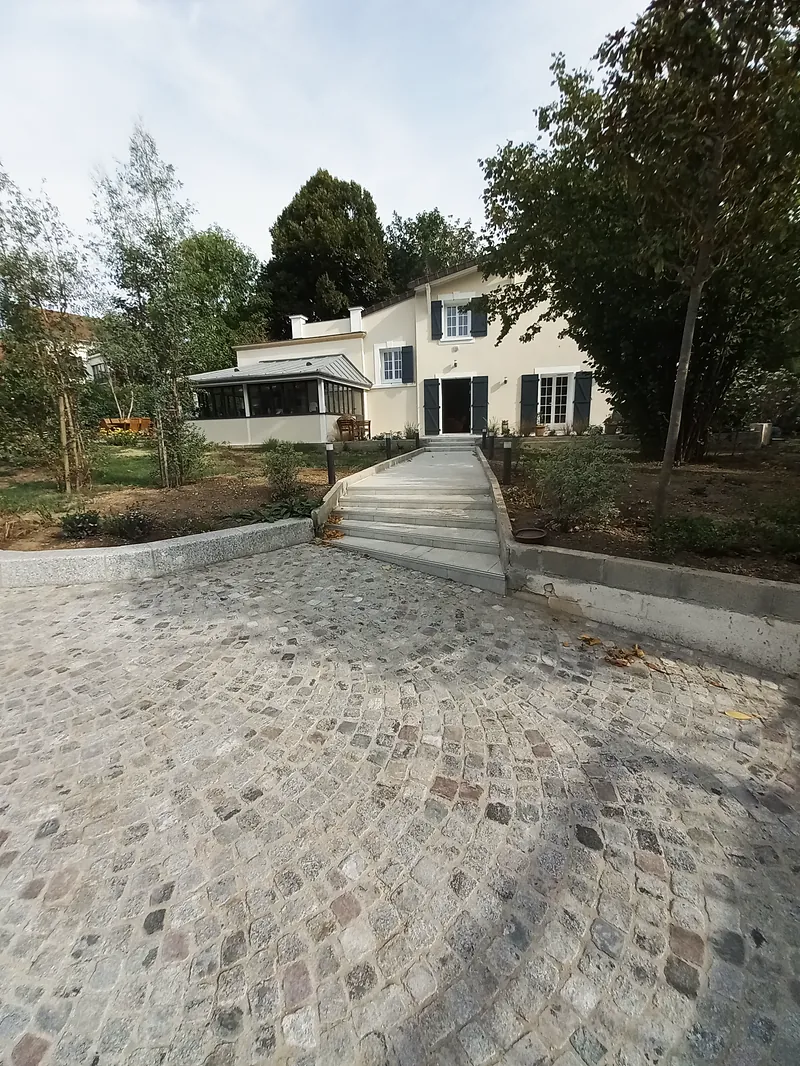 L’allée pavée et l’escalier qui monte vers la maison.