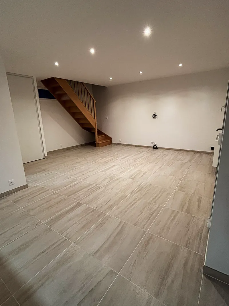Le séjour et l’escalier en bois.